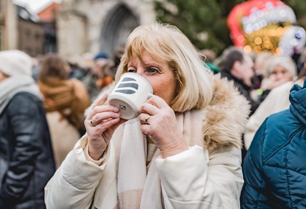 Vrouw drinkt uit Stad Diest koffiemok